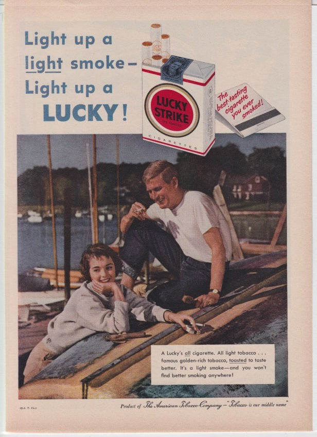 Vintage 1950s Lucky Strike cigarettes original print advertisement, young couple relaxing on sailboat rigging at a marina with Lucky Strike pack prominently displayed above
