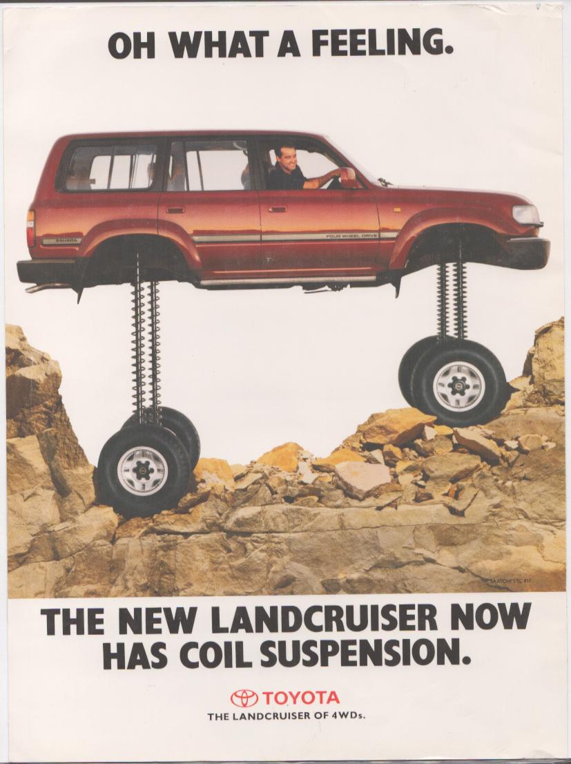 Vintage 1990s Toyota Land Cruiser original print advertisement, red FJ80 SUV elevated on giant coil springs over rocky terrain with 'Oh What a Feeling' headline