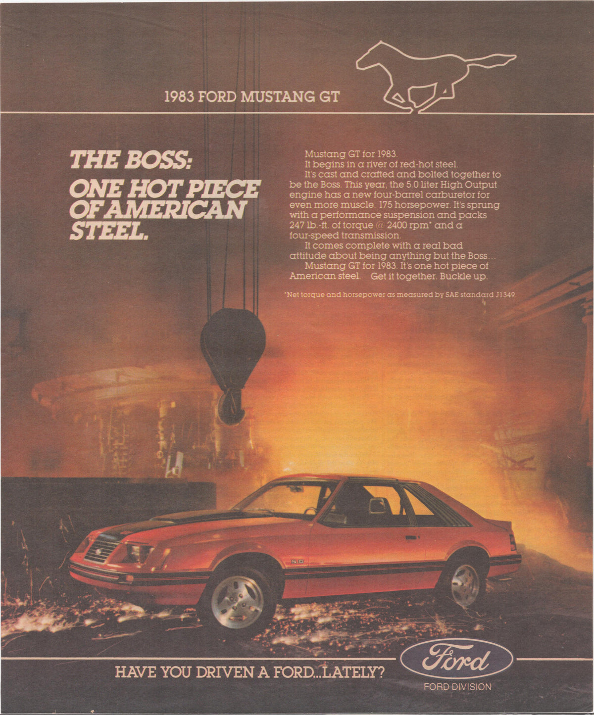 Vintage 1983 Ford Mustang GT original print advertisement, red Fox-body GT posed dramatically in front of a glowing steel mill with bold 'The Boss' headline