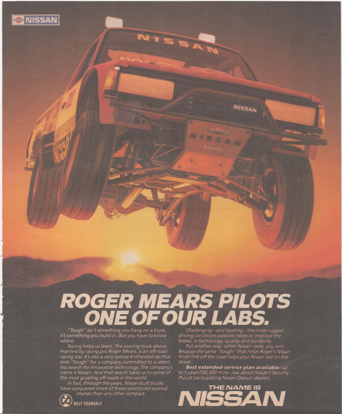 Vintage 1984 Nissan off-road racing truck original print advertisement, Roger Mears factory truck airborne against desert sunset with 'Roger Mears Pilots One of Our Labs' headline