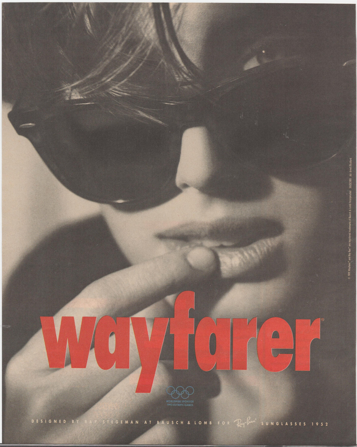 Vintage 1988 Ray-Ban Wayfarer original print advertisement, dramatic black and white close-up portrait of model wearing Wayfarer sunglasses with bold red Wayfarer wordmark and Olympic sponsor logo