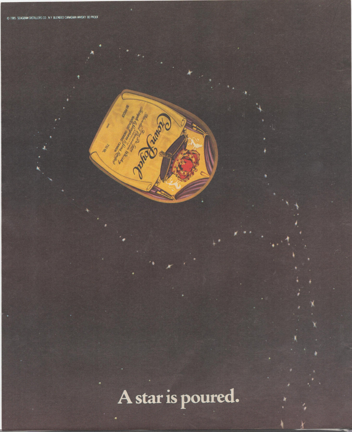 Vintage 1985 Crown Royal Canadian Whisky original print advertisement, iconic gold-labeled bottle floating in a dark star-filled night sky with tagline 'A star is poured'