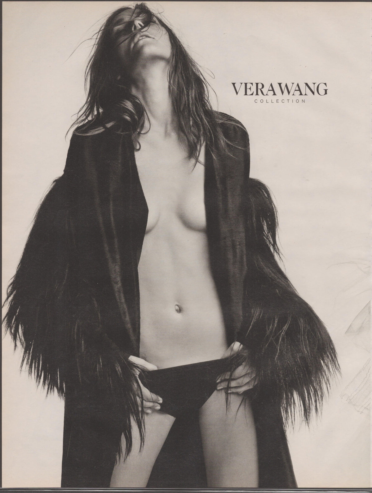 Vintage 1990s Vera Wang Collection original print advertisement, black and white editorial image of model in open fur-trimmed coat