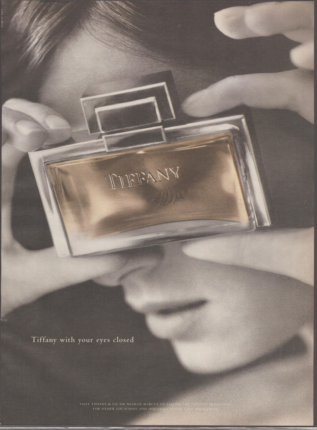Vintage 1990s Tiffany &amp; Co. fragrance original print advertisement, black and white close-up of woman holding Tiffany perfume bottle over her eyes with tagline 'Tiffany with your eyes closed'