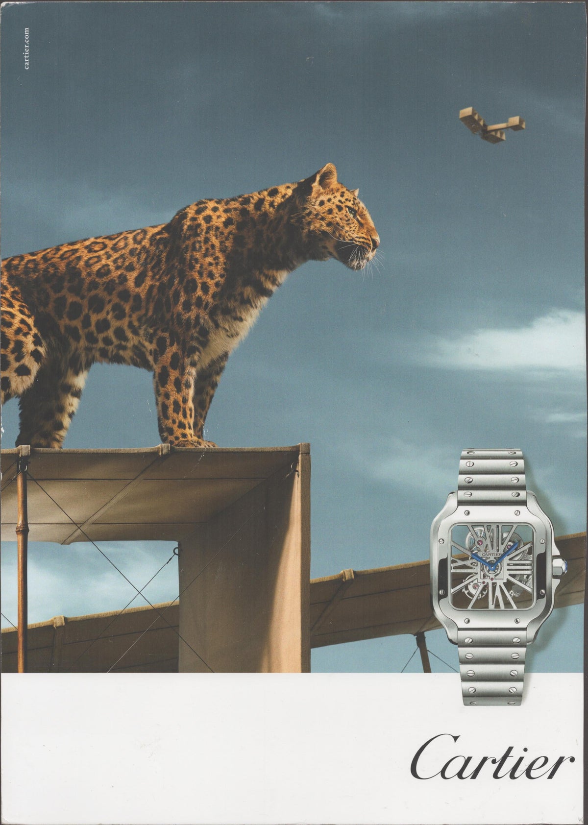 Vintage 2010s Cartier Santos Skeleton original print advertisement, leopard standing on vintage biplane wing with skeletonized watch and Cartier script logo