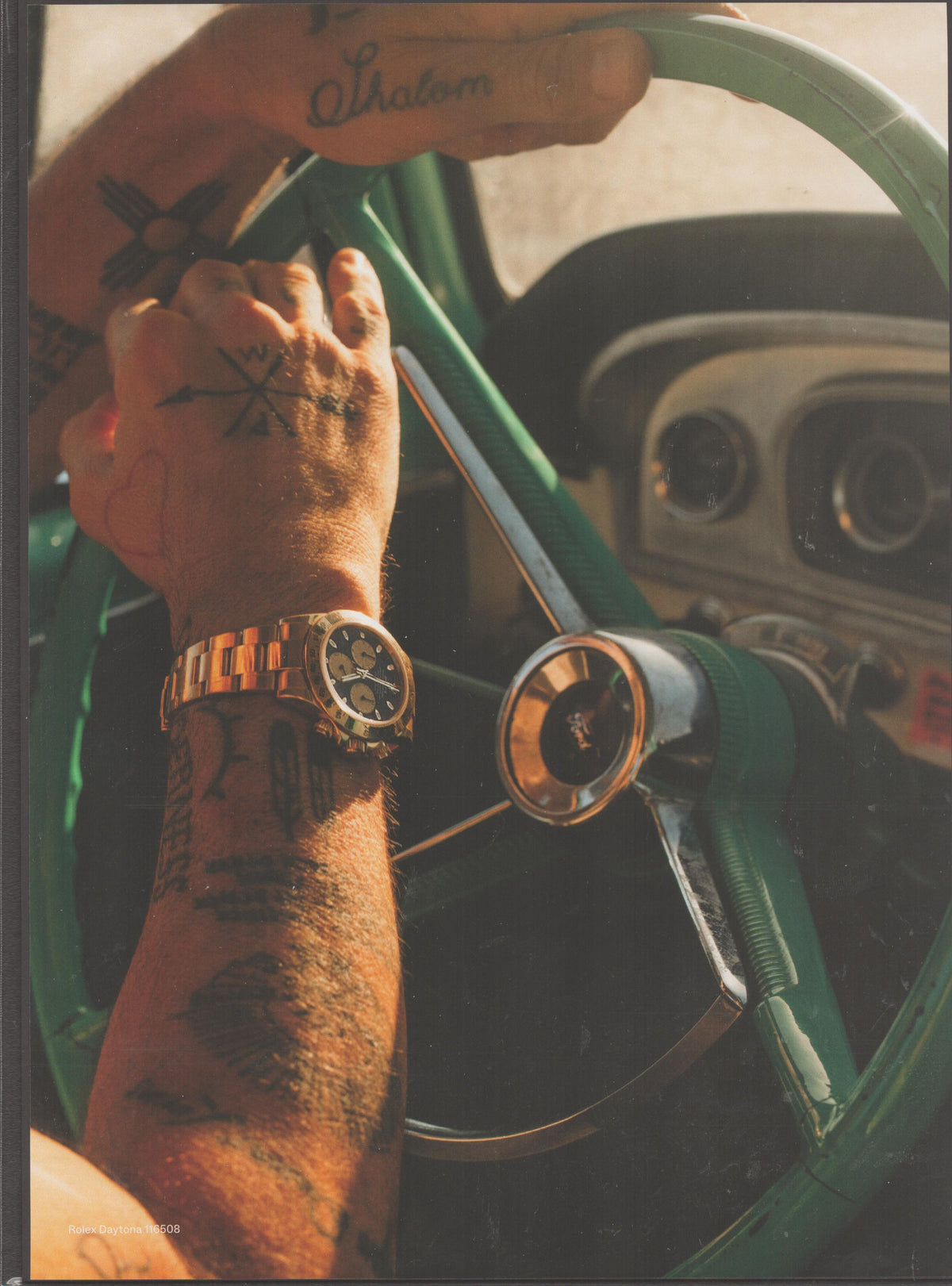 Vintage 1990s Rolex Daytona Ref. 16508 original print advertisement, tattooed wrist wearing yellow gold Rolex Daytona gripping vintage green car steering wheel
