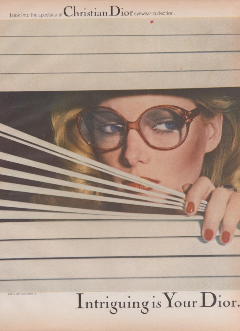 Vintage 1970s Christian Dior eyewear original print advertisement, blonde model peering through venetian blinds wearing oversized round frames, photographed by Chris von Wangenheim