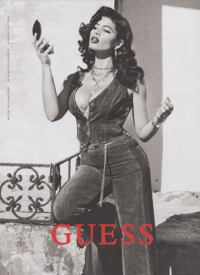 Vintage 2025 Guess denim original print advertisement, black and white photo of glamorous model in denim vest and wide-leg jeans with chain belt, photographed by Ellen Von Unwerth