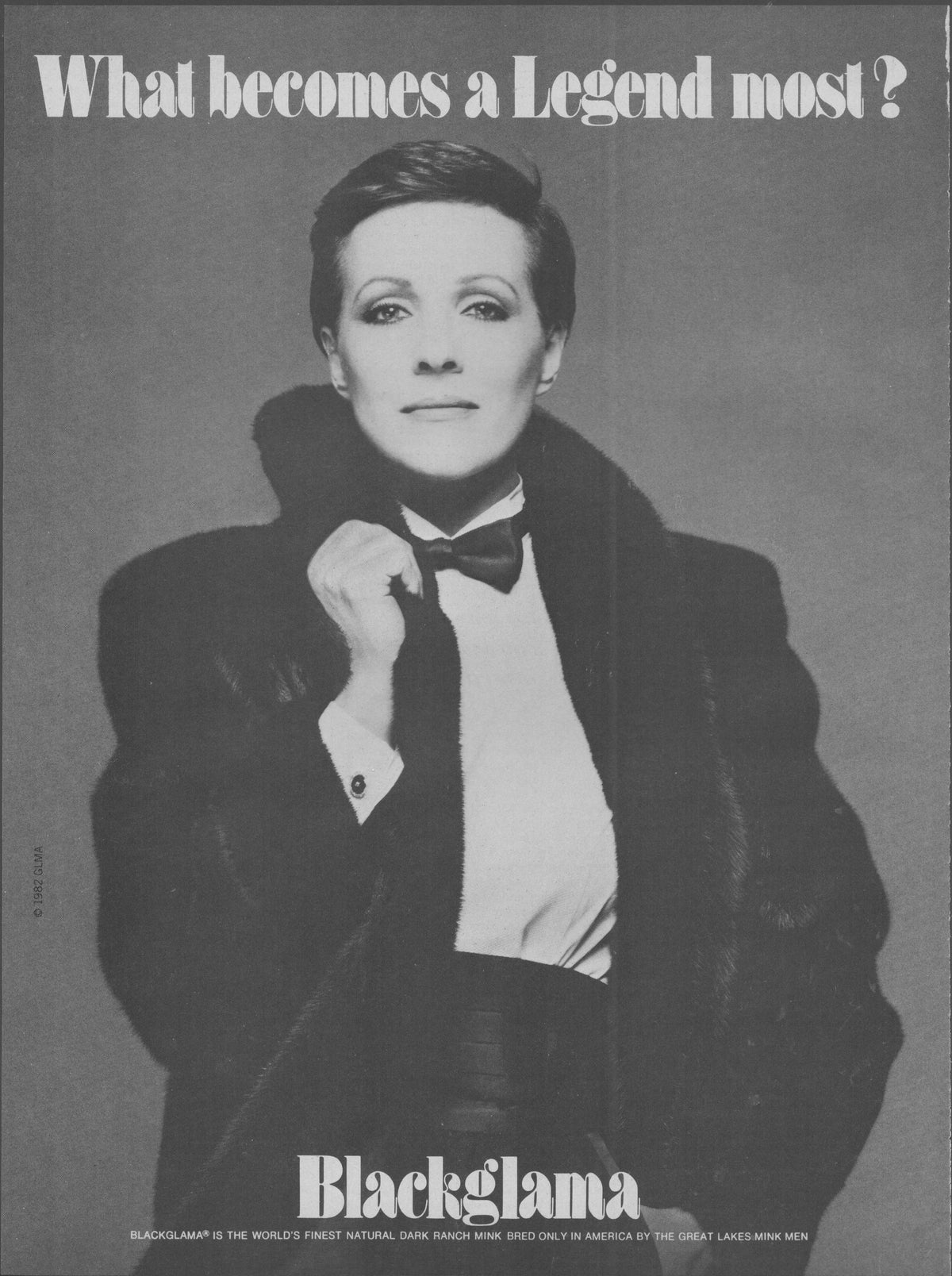 Vintage 1982 Blackglama mink original print advertisement, black and white image of short-haired celebrity wearing luxurious mink coat over tuxedo with bow tie, headline reads 'What Becomes a Legend Most?'
