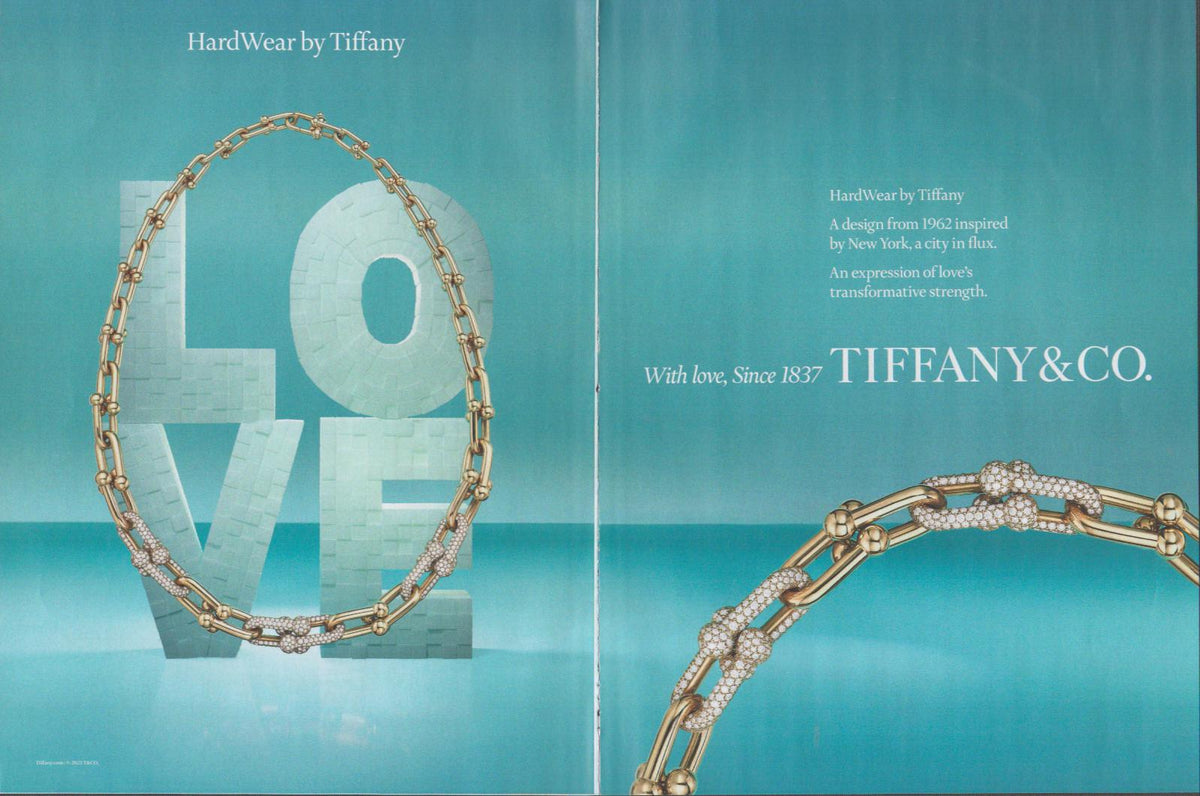 Vintage Tiffany & Co. HardWear original print advertisement, two-page spread featuring gold diamond-pavé link necklace draped over a LOVE sculpture against a teal background