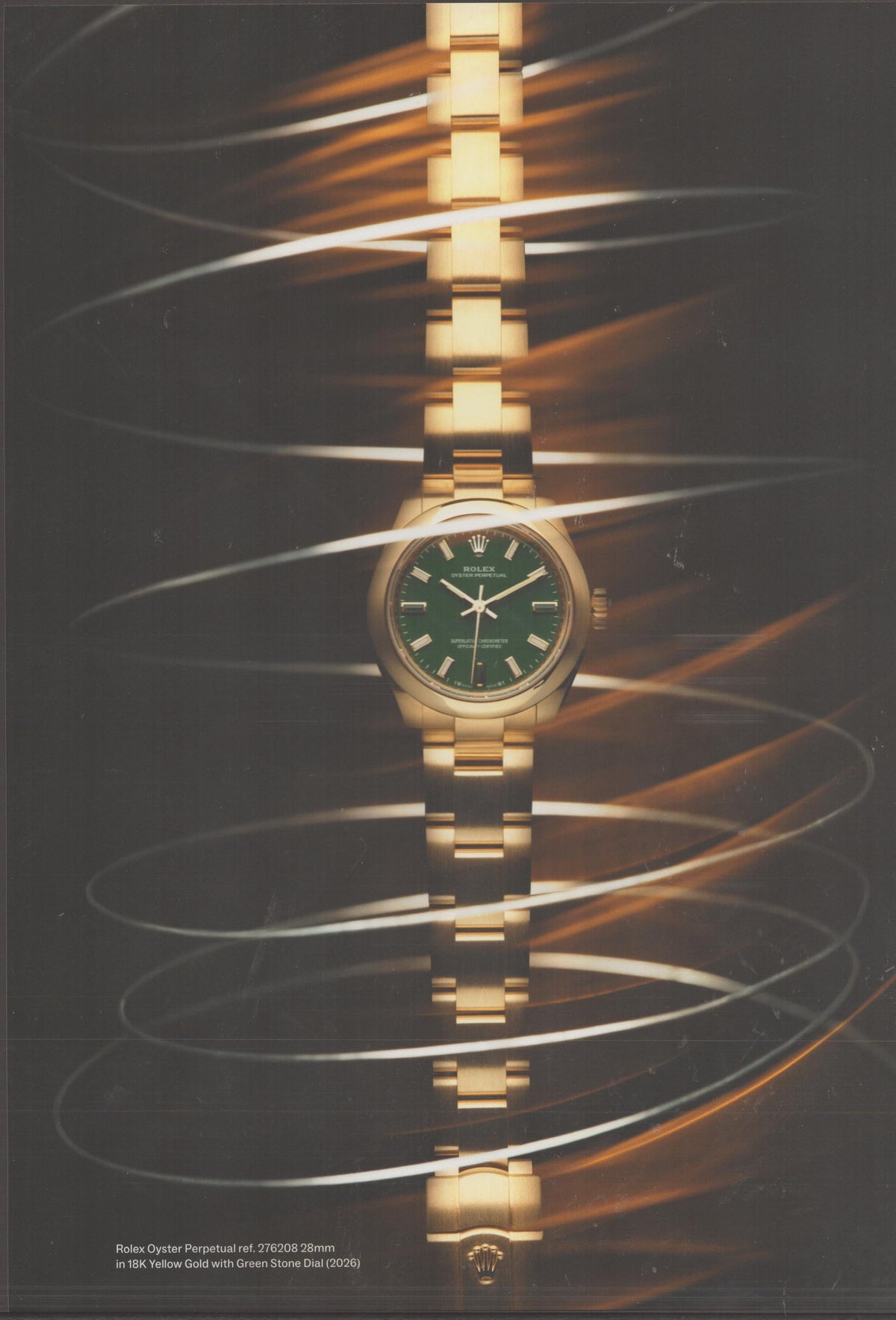 Vintage 2026 Rolex Oyster Perpetual ref. 276208 original print advertisement, 18K yellow gold watch with green stone dial surrounded by swirling light trails on dark background