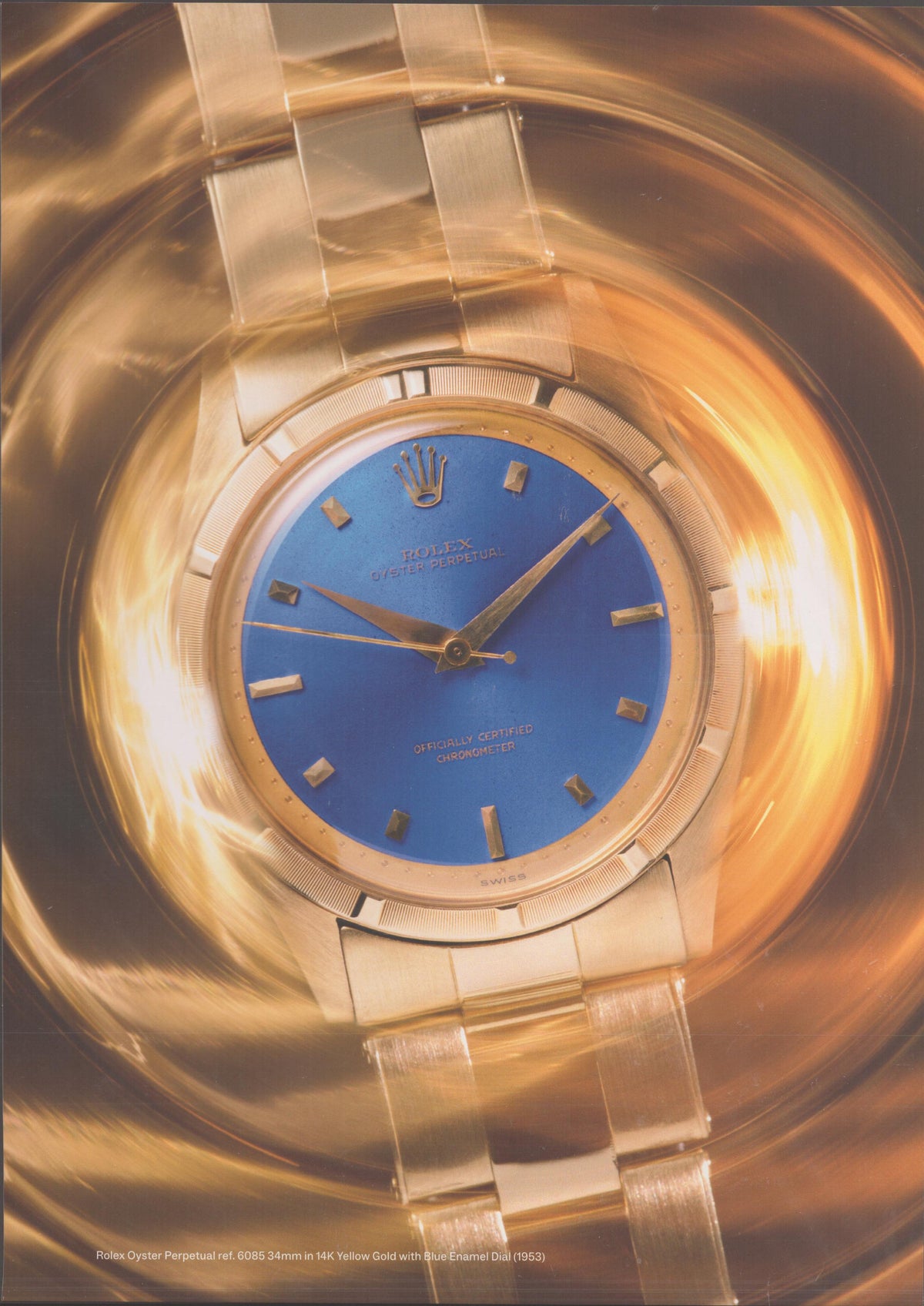 Vintage 1963 Rolex Oyster Perpetual Ref. 6085 original print advertisement, 14K yellow gold watch with blue enamel dial centered in a swirling golden vortex background