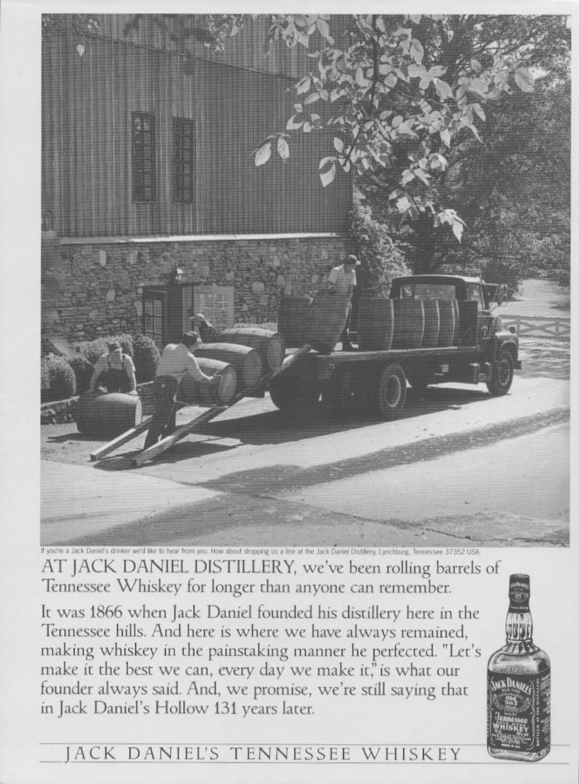 Vintage 1997 Jack Daniel's Tennessee Whiskey original print advertisement, black and white photo of workers rolling barrels off a flatbed truck at the Lynchburg distillery