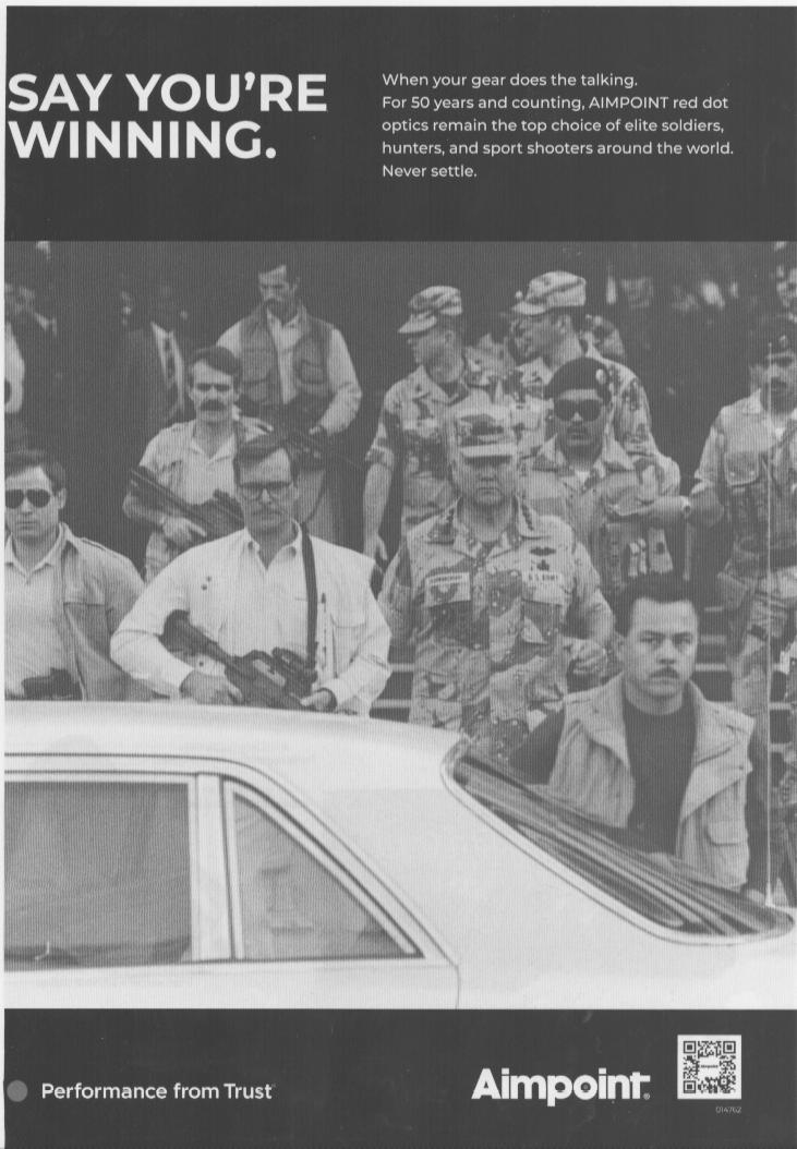 Vintage Aimpoint red dot optics original print advertisement, black-and-white image of armed soldiers and civilians surrounding a vehicle with bold 'Say You're Winning' headline