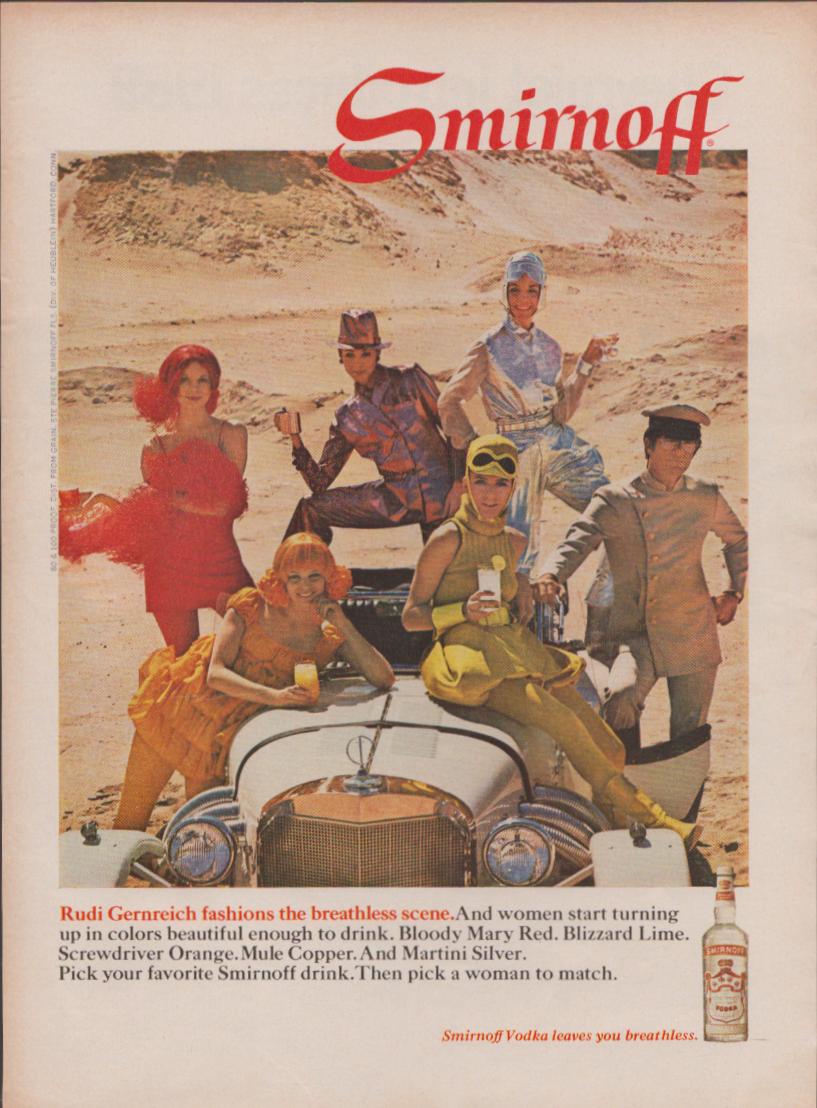 Vintage 1966 Smirnoff Vodka original print advertisement, models in colorful Rudi Gernreich cocktail-themed fashions posed on a vintage roadster in a desert setting