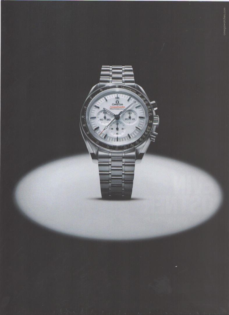 Vintage 2000s Omega Speedmaster Professional original print advertisement, steel chronograph watch illuminated by single dramatic spotlight on dark grey background