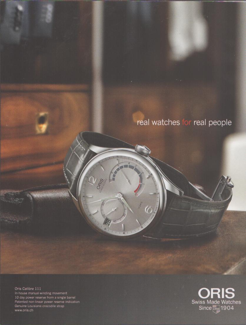 Vintage 2000s Oris Calibre 111 original print advertisement, silver dial dress watch with crocodile strap resting on leather case with mahogany cabinet background