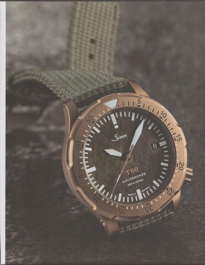 Vintage 2010s Sinn T50 Goldbronze original print advertisement, bronze dive watch on olive NATO strap against dark stone surface